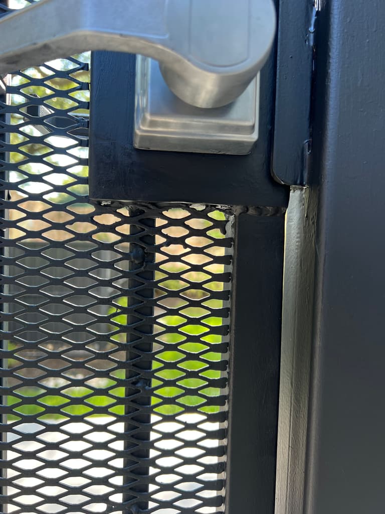 The same gate lock box rebuilt in new steel and painted black, with a clean square edge under the handle